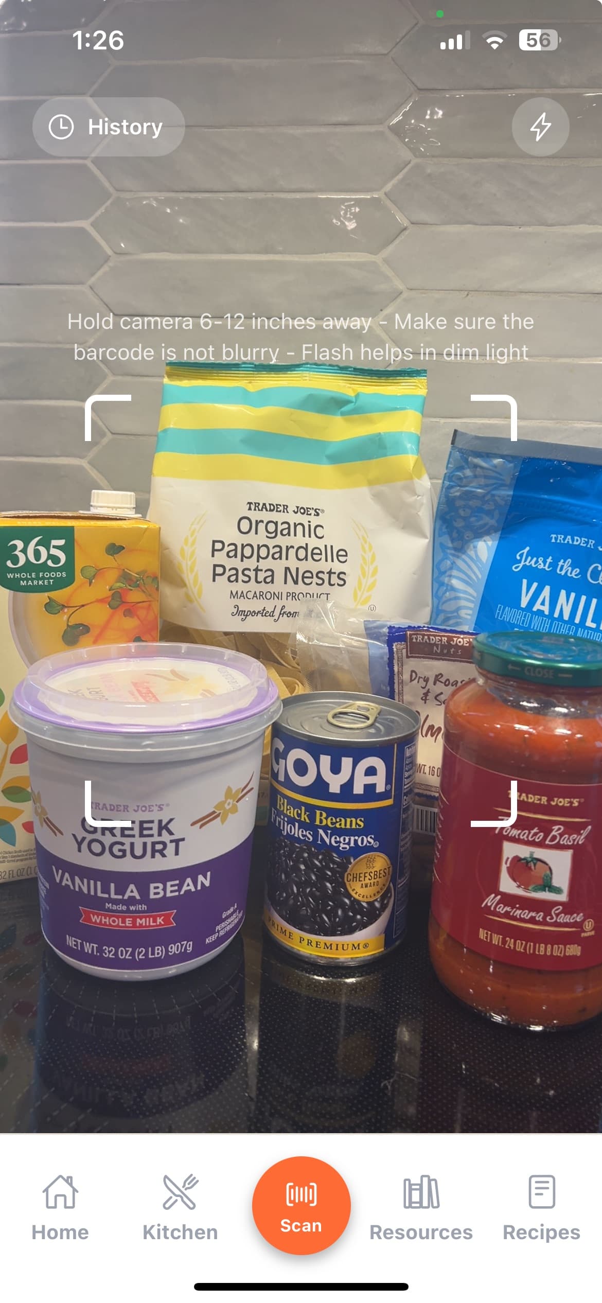 Good Roots barcode scanner pointed at groceries on a kitchen counter